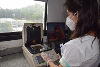 Persona utilizando un equipo para hacer  PCR del Laboratorio de Salud Pública